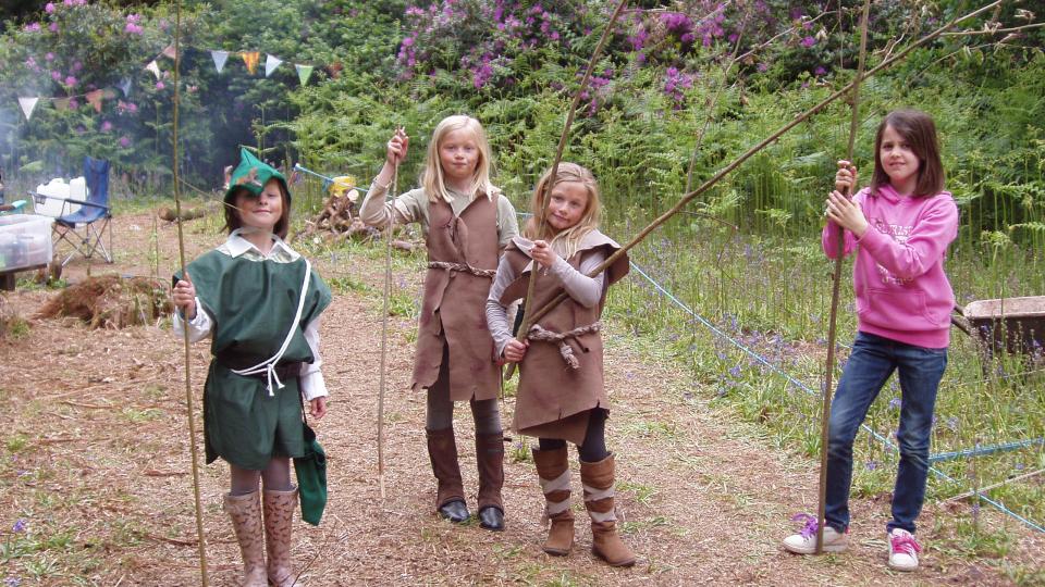 Children playing in costumes in the woods